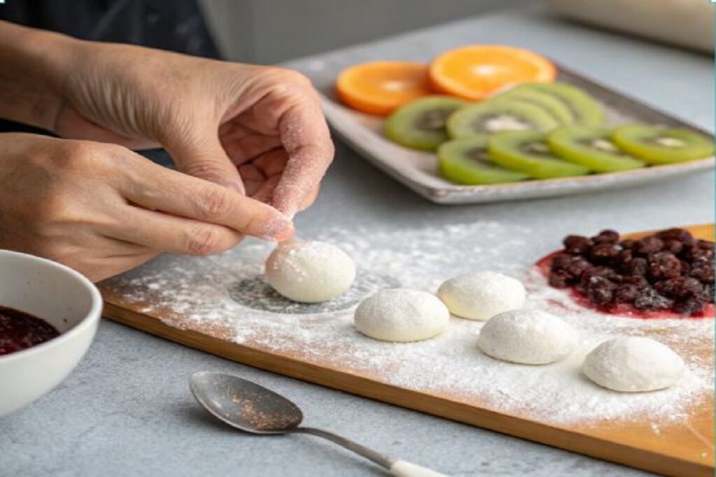 Main façonnant du mochi sur un plan de travail, représentant la technique artisanale.